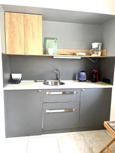 uma cozinha com um lavatório e uma bancada em Crystal Clear - 2 separate bedrooms and PARKING em Comotini