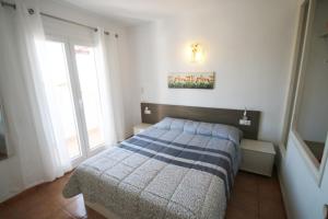 ミアミ・プラトーヤにあるCasas Blancas 12のベッドルーム1室(青と白の毛布付きのベッド1台付)