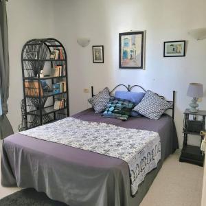1 dormitorio con 1 cama grande con almohadas azules en Djerba chambres d'hôtes en Houmt El Souk