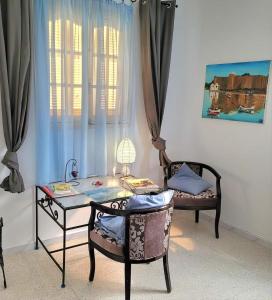 a desk and chair in a room with a window at Djerba chambres d'hôtes in Houmt Souk