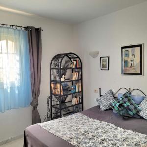 Djerba chambres d'hôtes في حومة السوق: غرفة نوم مع سرير ورف كتاب