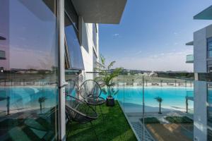 Blick auf den Pool vom Balkon eines Gebäudes in der Unterkunft Dar Alsalam - Modern Comforts in Dubai District One Residence 29 in Dubai