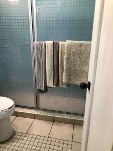 a bathroom with a shower with towels and a toilet at Quetzal House in Tijuana