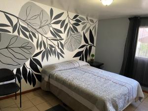 Schlafzimmer mit einem Bett mit einer schwarz-weißen Wand in der Unterkunft Quetzal House in Tijuana