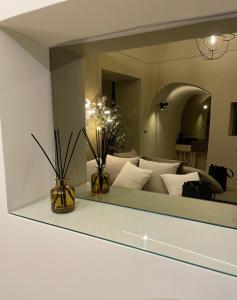 un miroir reflétant un salon avec un canapé blanc dans l'établissement HP Luxury Suite Taormina, à Taormine