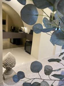Cette chambre comprend une table avec un vase et une statue. dans l'établissement HP Luxury Suite Taormina, à Taormine