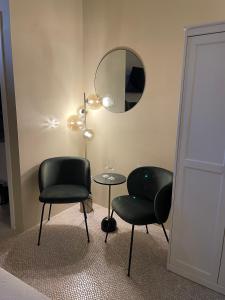 une chambre avec deux chaises, une table et un miroir dans l'établissement HP Luxury Suite Taormina, à Taormine