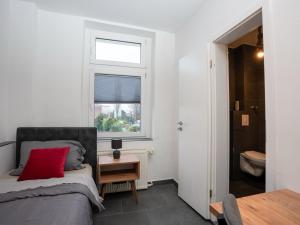 a bedroom with a bed with a red pillow and a window at SR24 - Space in Oer-Erkenschwick in Oer-Erkenschwick