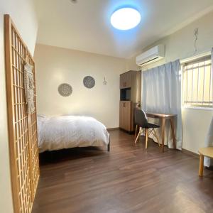 een slaapkamer met een bed, een bureau en een stoel bij 林林の民宿-関空直達,通天閣近い, 3階建て一軒家 in Osaka