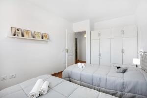 a white bedroom with two beds and white cabinets at Casa Oramas ll in Puertito de Güímar +20 photos