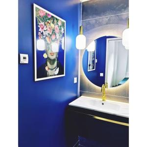 a blue bathroom with a sink and a mirror at Chalet côté montagne in Oz