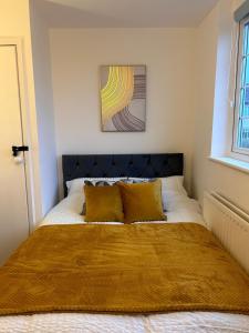 a bed with a black headboard in a bedroom at May Disc - Long Stay - Contractors in Mangotsfield