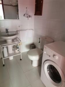 a bathroom with a toilet sink and a washing machine at apartamento Mirada I 22 ET-294PL in Es Pujols
