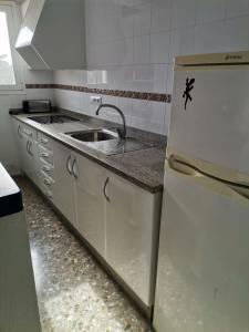 a kitchen with a sink and a refrigerator at apartamento Mirada I 22 ET-294PL in Es Pujols