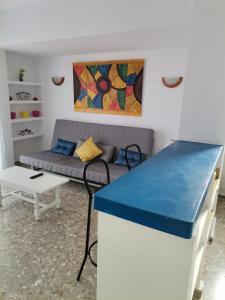 un soggiorno con divano e bancone blu di apartamento Mirada I 22 ET-294PL a Es Pujols