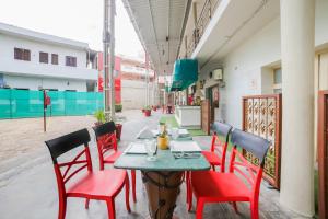 un ristorante con sedie rosse e un tavolo in un edificio di Super Townhouse 1267 Dayal Lodge - A Boutique Hotel ad Agra