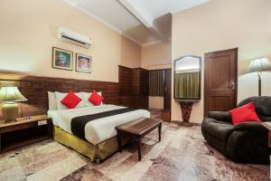 una camera d'albergo con letto e divano di Super Townhouse 1267 Dayal Lodge - A Boutique Hotel ad Agra