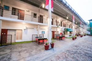 un grand bâtiment avec des tables et des chaises dans une cour dans l'établissement Super Townhouse 1267 Dayal Lodge - A Boutique Hotel, à Agra