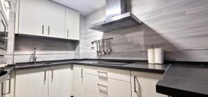 a large kitchen with white cabinets and a sink at DS Casa San Fernando in Córdoba