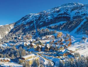 a ski resort covered in snow with a mountain at Chalet côté montagne in Oz