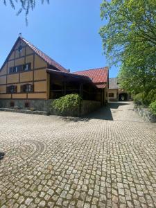 a building with a cobblestone driveway in front of it at Agroturystyka Agro-Podkówka in Marciszów