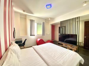 a bedroom with a bed and a flat screen tv at Amura Hotel Thủ Đức in Ho Chi Minh City
