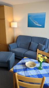 sala de estar con sofá azul y mesa en Haus Metropol App 103, en Westerland