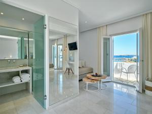 a bathroom with a glass shower and a table at Kanale's Rooms & Suites in Naousa