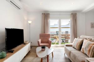 a living room with a couch and a tv at Apartamento Suite Arco Solo Parejas in Conil de la Frontera