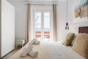 a white bedroom with a bed with towels on it at Apartamento Suite Arco Solo Parejas in Conil de la Frontera