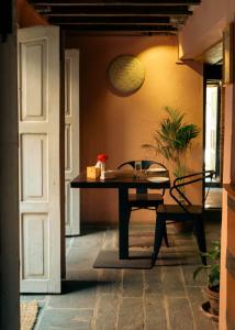 a table and a chair in a room with a door at Manju Baha Hotel & Restaurant in Bhaktapur