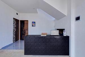 SPOT ON Anay Inn في ناغبور: غرفة بيضاء مع مكتب مع لاب توب عليه