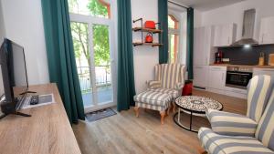 een woonkamer met een tv en een tafel en stoelen bij Georgentor in Naumburg