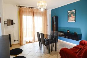 una sala de estar azul con mesa y sillas en Casa Vacanza Il Dolce Mare, en Alghero