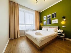 Un dormitorio con una cama con paredes verdes y una ventana en Grand Turan Business 2-Room Apartament's, en Astana