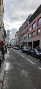 an empty city street with parked cars and buildings at Appartement paisible in Clichy