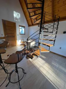 escalera de caracol en una habitación con mesa y sillas en VILLA ITÁLIA CHALÉ, en Santo Antônio do Pinhal