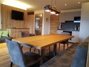 Aparthotel Hohe Brücke-NPHT Sommercard inklusive في ميترسيل: مطبخ وغرفة طعام مع طاولة وكراسي خشبية