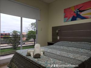 een slaapkamer met 2 bedden en een groot raam bij Bienestar Federación ZONA CENTRO in Federación