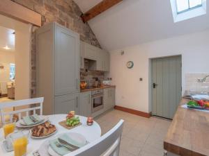 a kitchen with a white table with food on it at Nook Cottage, Hot Tub, Polar Bears, Alton Towers, Bakewell, Chatsworth House, Peak District Stay in Foxt