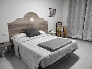 a bedroom with a large bed with a wooden headboard at TANISHOSTALRESTAURANTE in Riaño