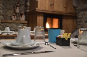 a table with white plates and utensils on a table at Le Suites de San Campel RTA in Ponte di Legno +34 photos