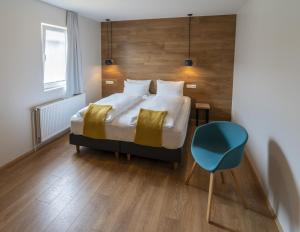 1 dormitorio con 1 cama y 1 silla azul en Stracta Hotel, en Hella