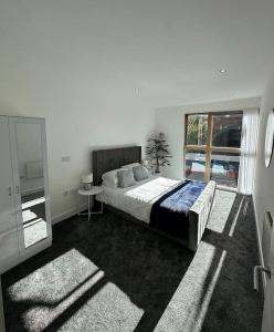ein Schlafzimmer mit einem Bett und einem großen Fenster in der Unterkunft Manchester's Prime - Luxurious 1-Bed Flat in Manchester