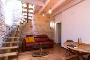sala de estar con sofá y escalera de caracol en Le Nicchie luxury rooms, en Lecce