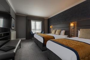 um quarto de hotel com duas camas e um sofá em Clybaun Hotel em Galway