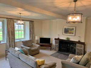 un salon avec un canapé et une cheminée dans l'établissement Finest Retreats - Ingleby Manor - Courtyard Cottage, à Great Ayton