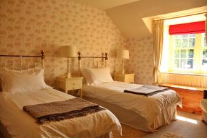 a bedroom with two beds and a window at Finest Retreats - Ingleby Manor - Courtyard Cottage in Great Ayton