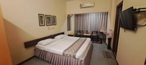 Habitación de hotel con cama y ventana en Hotel Swaroop, en Pune