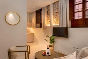 uma sala de estar com uma mesa e uma televisão em Coeo Apart-Hotel Fresca em Málaga
